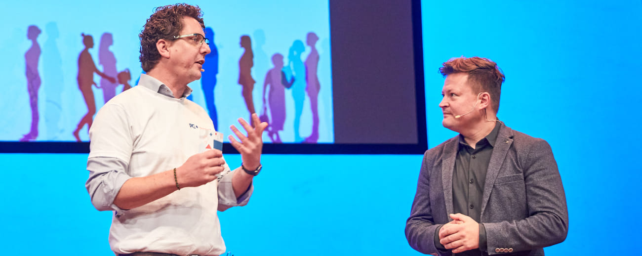 Dries Hettinga, directeur PGOsupport, en dagvoorzitter Gijs Nillessen met elkaar in gesprek op het podium van de plenaire zaal.ire programma in