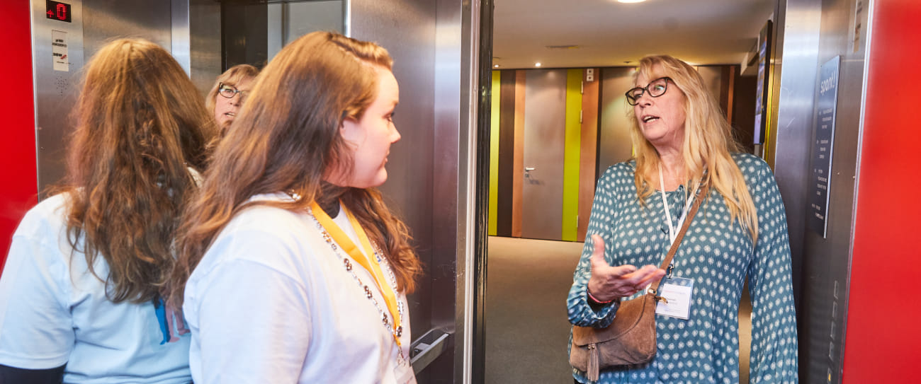 adviseur fondsenwerving Winona Verlinden staat met een congresdeelnemer in de lift voor een elevatorpitch